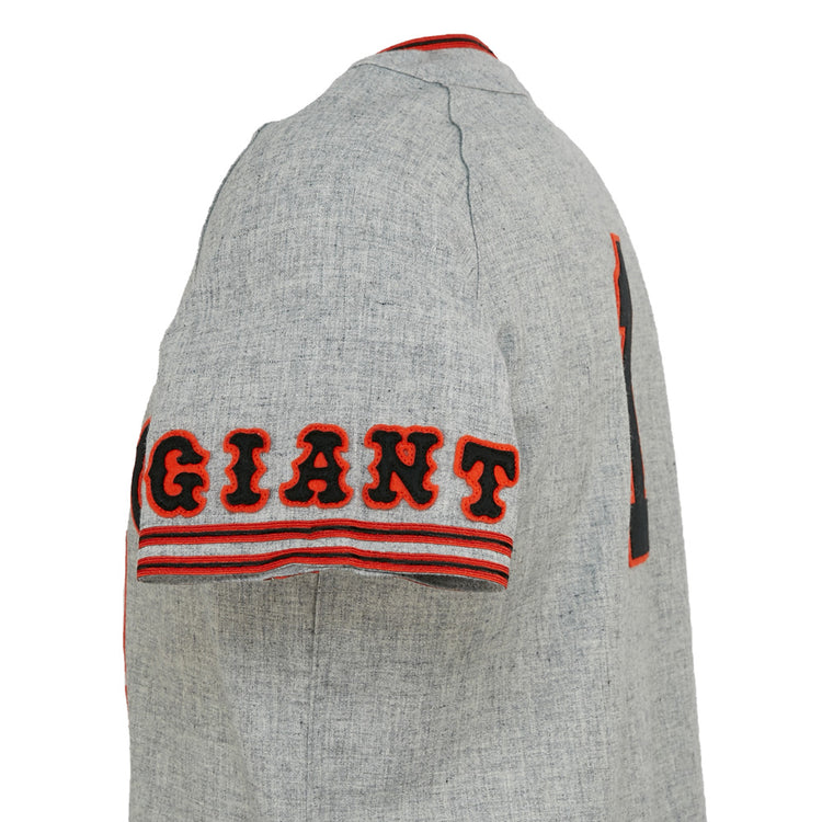 A close-up side view of the EFF Tokyo Kyojin (Giants) 1961 Road Jersey, featuring bold black and orange GIANT lettering on the sleeve, red-striped trim, and Sadaharu Oh’s iconic number 1 partly visible on the back.