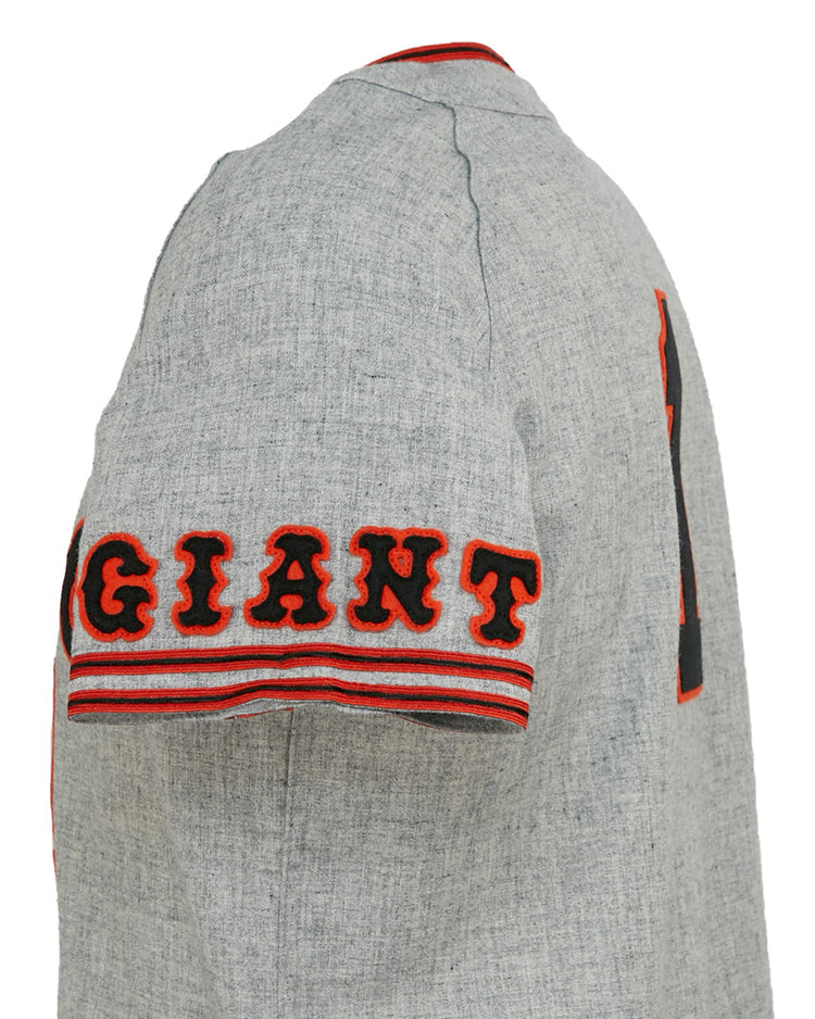 A close-up side view of the EFF Tokyo Kyojin (Giants) 1961 Road Jersey, featuring bold black and orange GIANT lettering on the sleeve, red-striped trim, and Sadaharu Oh’s iconic number 1 partly visible on the back.