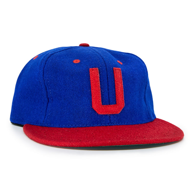 The EFF Utica Blue Sox 1950 Vintage Ballcap is blue with a red brim, red stitching, and a bold red U on the front—replicating the classic look of an original Utica Blue Sox cap.