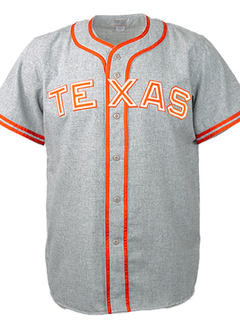 The EFF University of Texas 1941 Road Jersey is a gray baseball jersey with orange and white trim on the collar, placket, and sleeves, featuring bold “TEXAS” lettering inspired by the 1941 vintage design.