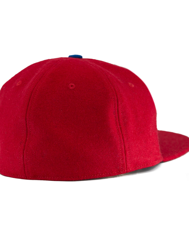 The EFF Wembley Lions 1957 Vintage Ballcap features bright red hand-sewn wool, a rounded crown, blue top button, and no visible strap, capturing the classic look of British National Hockey League styles from the back view.