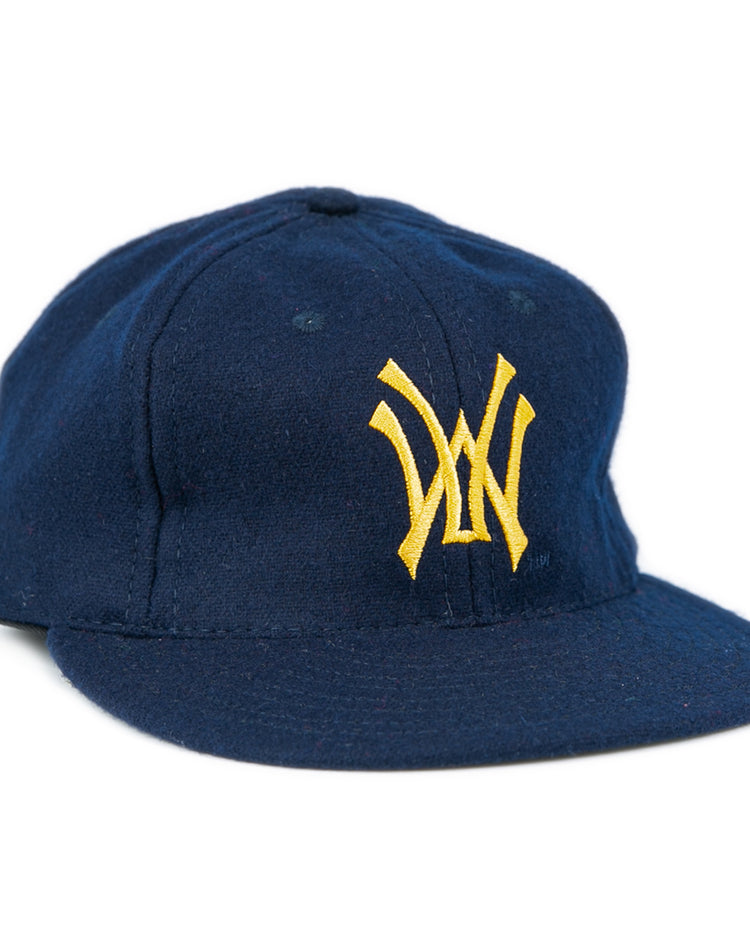 The West Virginia University 1966 Vintage Ballcap by Ebbets Field Flannels is a dark blue cap with a flat brim and yellow interlocking W logo, inspired by the classic style of the 1966 Mountaineers.