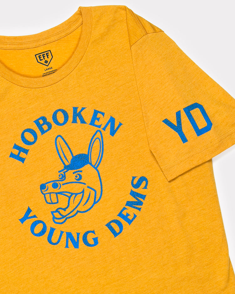 The Ebbets Field Flannels Hoboken Young Democrats T-Shirt is a yellow unisex tee with blue HOBOKEN YOUNG DEMS text around a cartoon donkey, plus blue YD on the left sleeve—great for Little League events.