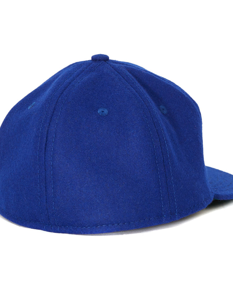 The EFF Cal State Fullerton 1965 Vintage Ballcap is shown from the back in royal blue, featuring visible stitching, ventilation eyelets, and a partially visible curved brim on the right.