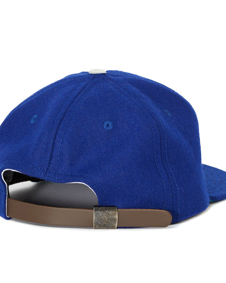 The EFF Oakland Oaks 1950 Vintage Ballcap features blue fabric, a white top button, and a brown adjustable strap with metal clasp—classic style echoing the original Pacific Coast League design.