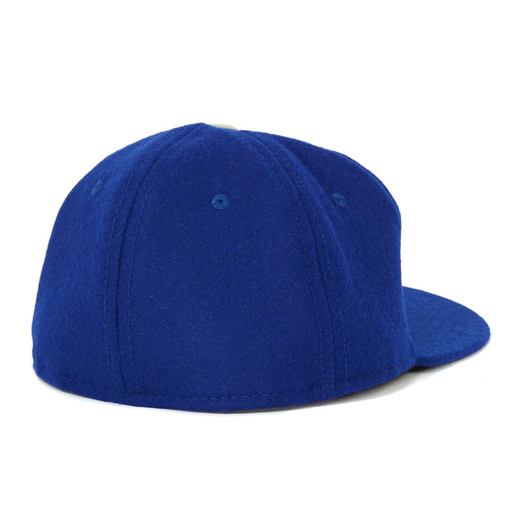 The EFF Oakland Oaks 1950 Vintage Ballcap is shown from the back left, featuring plain royal blue fabric, visible stitching, and ventilation holes. It channels classic Pacific Coast League style with no logos or designs visible.